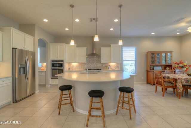 27552 W Tonopah Dr, Buckeye, AZ 85396 - kitchen featuring appliances with stainless steel finishes, wall chimney range hood, backsplash, light countertops, and light tile patterned flooring