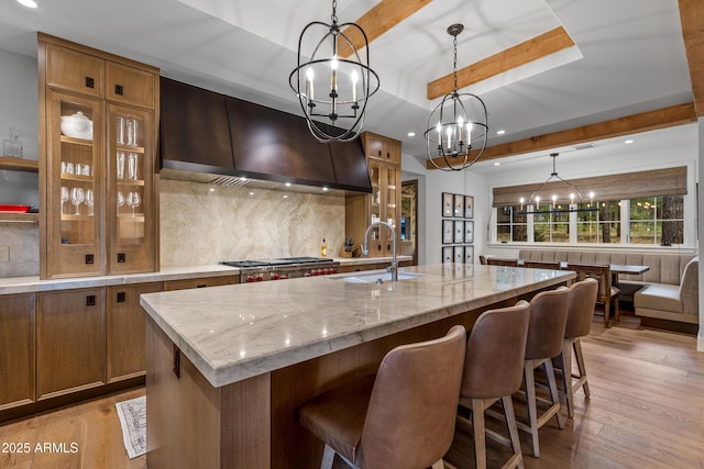 kitchen featuring a notable chandelier, recessed lighting, a sink, and custom range hood