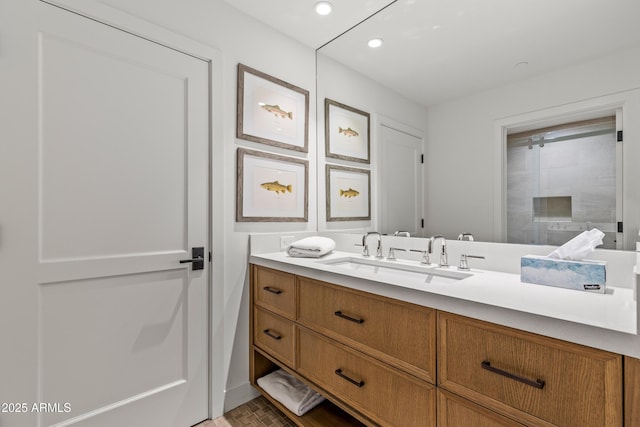 full bathroom featuring tiled shower, vanity, and recessed lighting