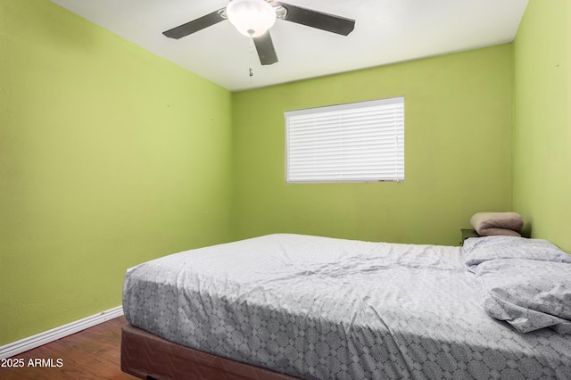 bedroom featuring a ceiling fan, baseboards, and wood finished floors