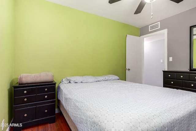 bedroom with ceiling fan, visible vents, and dark wood-type flooring