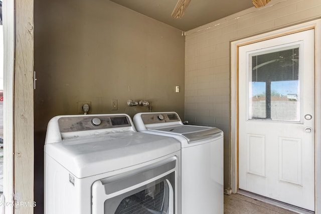 laundry area with washing machine and dryer, laundry area, ceiling fan, and concrete block wall