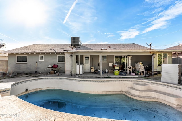 view of swimming pool featuring a patio area, cooling unit, and a hot tub