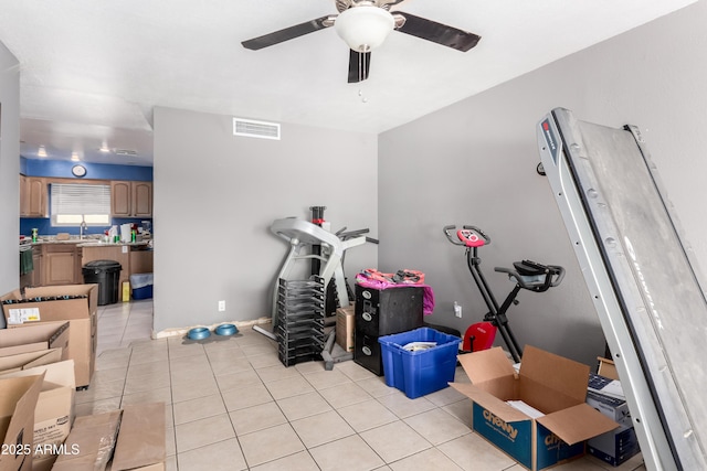 workout room featuring light tile patterned floors, a sink, visible vents, and a ceiling fan