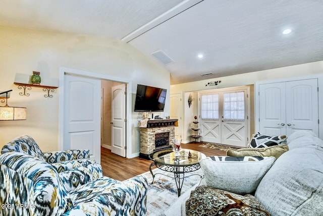 living room featuring a fireplace, recessed lighting, vaulted ceiling with beams, and wood finished floors