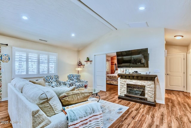 living area with visible vents, wood finished floors, baseboards, and vaulted ceiling with beams