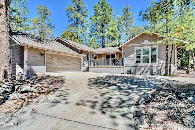 single story home featuring concrete driveway, a shingled roof, a porch, and a garage