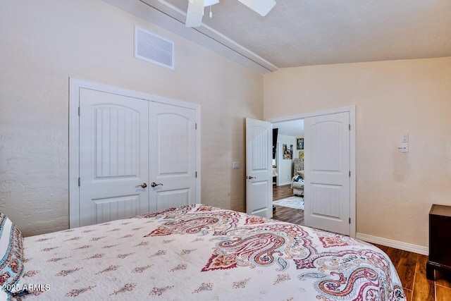 bedroom featuring wood finished floors, a ceiling fan, a closet, visible vents, and baseboards