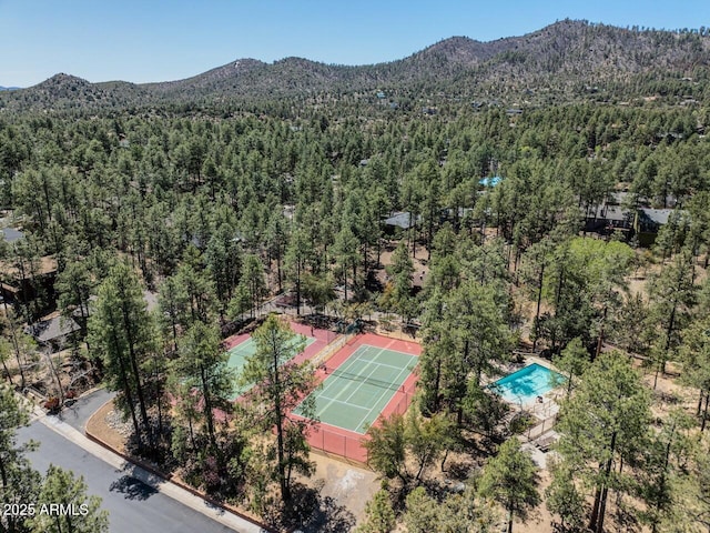 birds eye view of property featuring a forest view and a mountain view