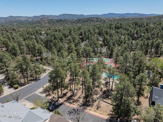 drone / aerial view featuring a forest view and a mountain view