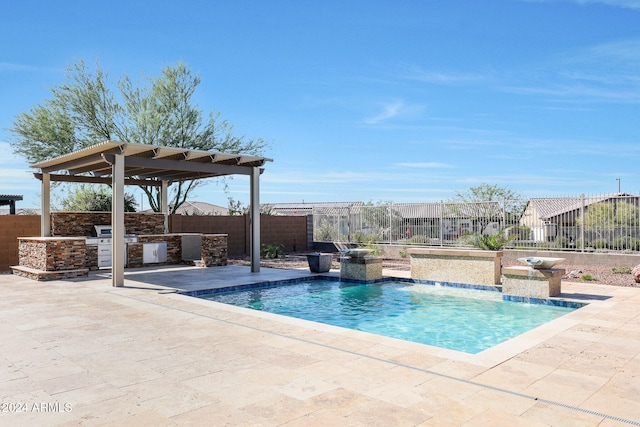 view of swimming pool featuring a patio area, pool water feature, and an outdoor kitchen