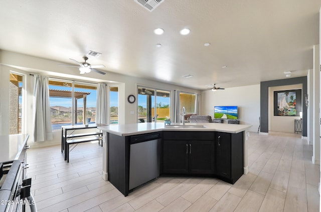 kitchen featuring light hardwood / wood-style flooring, stainless steel dishwasher, a center island with sink, and sink