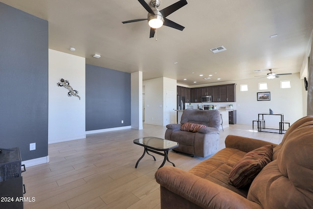 living room featuring light hardwood / wood-style floors and ceiling fan