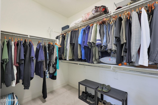 walk in closet featuring light colored carpet