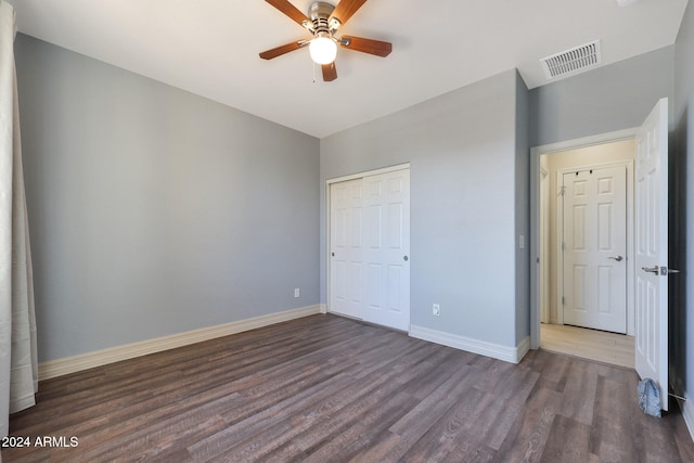 unfurnished bedroom with a closet, ceiling fan, and dark hardwood / wood-style floors