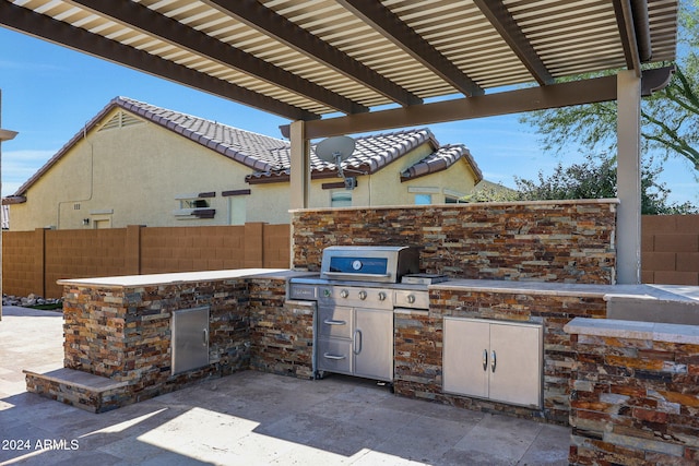 view of patio / terrace with exterior kitchen and a pergola