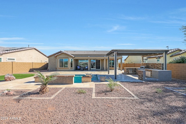 rear view of house featuring an outdoor kitchen, a patio area, and a pergola