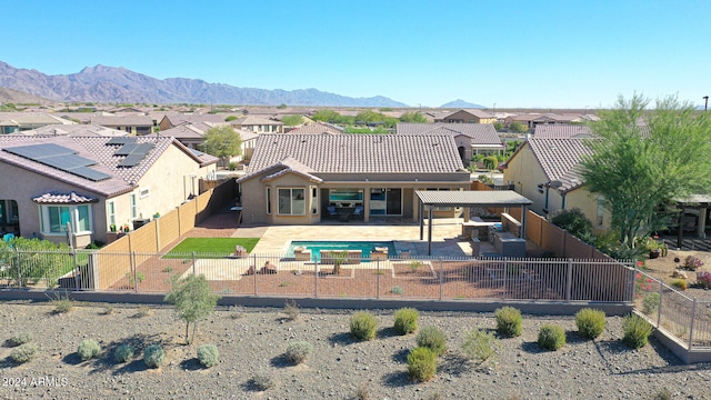 rear view of property with a mountain view and a patio area