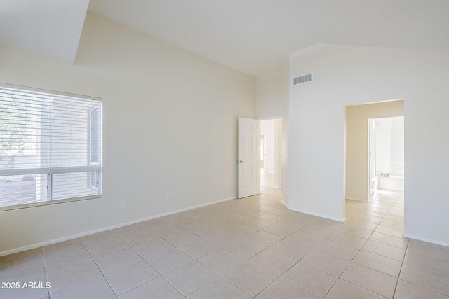 empty room featuring visible vents, baseboards, high vaulted ceiling, and light tile patterned flooring