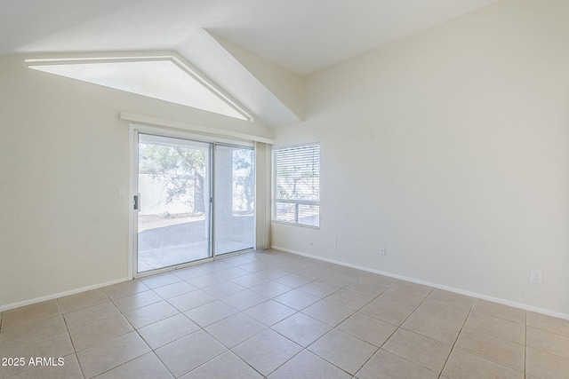 tiled spare room featuring baseboards and lofted ceiling