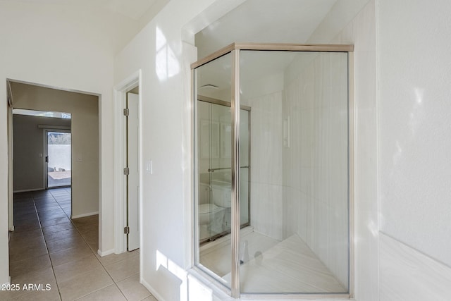 full bathroom featuring tile patterned floors, toilet, and a shower stall