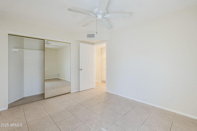 unfurnished bedroom with light tile patterned floors, visible vents, baseboards, and a closet