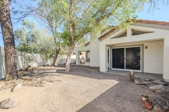 back of property with stucco siding and a fenced backyard