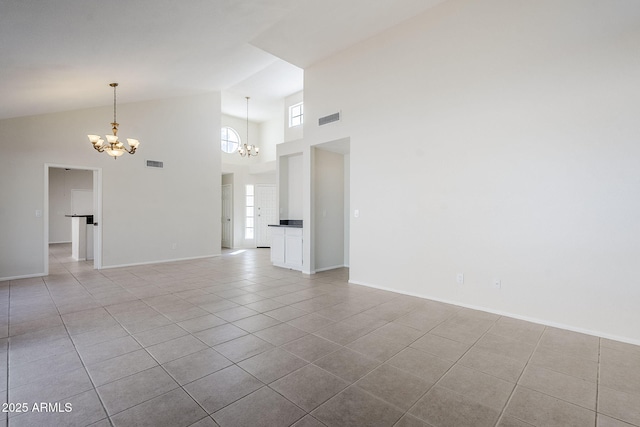 spare room featuring high vaulted ceiling, light tile patterned floors, visible vents, and a chandelier