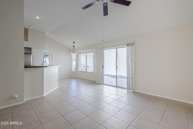 spare room with light tile patterned flooring, a ceiling fan, baseboards, and a sink