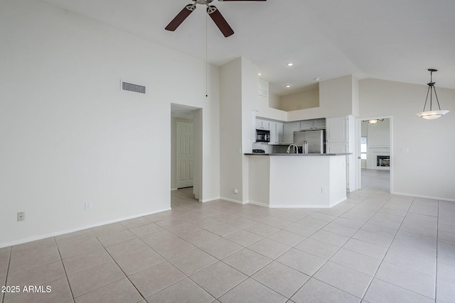 unfurnished living room with high vaulted ceiling, light tile patterned floors, visible vents, and ceiling fan