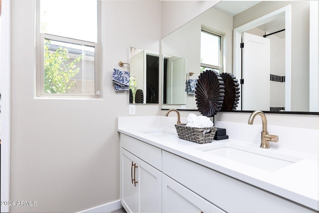 bathroom with a healthy amount of sunlight and dual bowl vanity