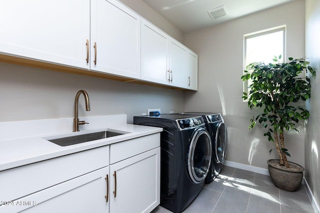 laundry room with light tile patterned flooring, sink, washer and dryer, and cabinets