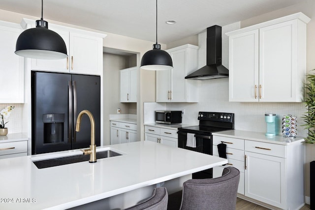 kitchen featuring wall chimney range hood, pendant lighting, tasteful backsplash, and black appliances