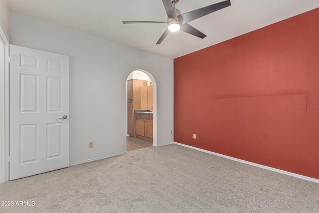 750 E Northern Ave Unit 2045, Phoenix, AZ 85020 - unfurnished bedroom featuring carpet floors, arched walkways, connected bathroom, and a ceiling fan