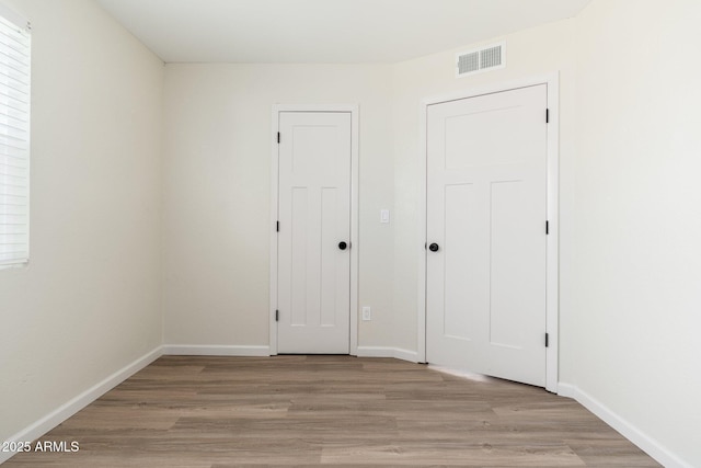 20818 N 21st Dr, Phoenix, AZ 85027 - unfurnished bedroom with light wood-style floors, baseboards, and visible vents