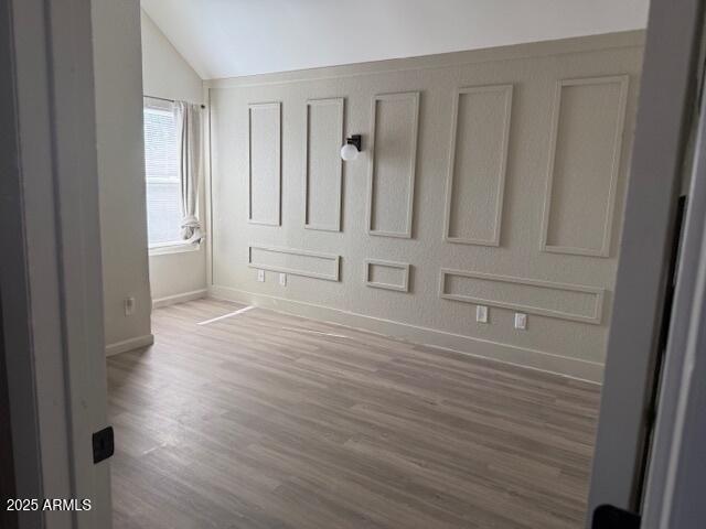 20818 N 21st Dr, Phoenix, AZ 85027 - unfurnished bedroom featuring baseboards, vaulted ceiling, and wood finished floors