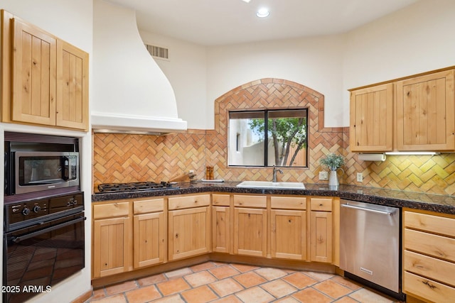 kitchen with tile countertops, light brown cabinets, stainless steel appliances, and a sink