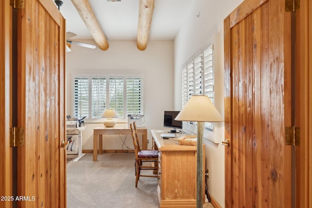 carpeted office space with beamed ceiling and baseboards