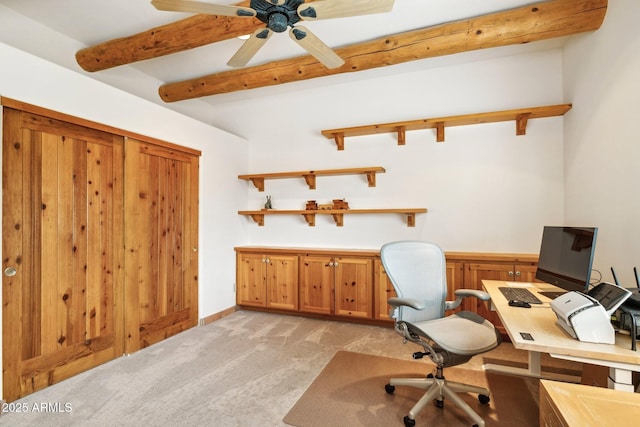 office featuring beamed ceiling, light colored carpet, and a ceiling fan