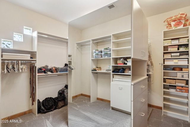 spacious closet featuring light colored carpet and visible vents