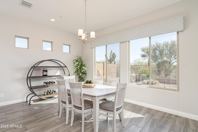 dining room with wood-type flooring and a chandelier