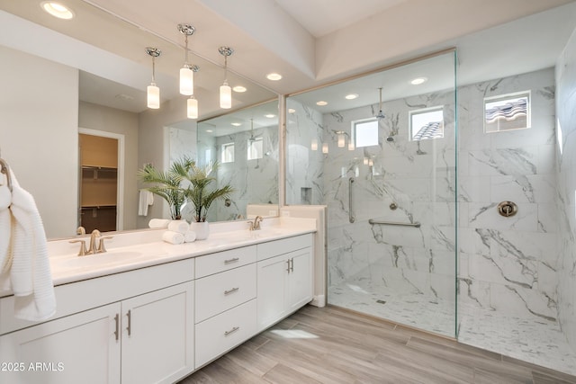 bathroom with tiled shower and vanity