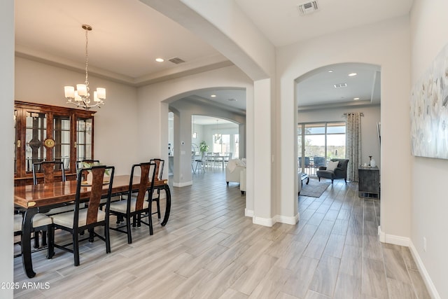 dining area featuring a tray ceiling and a notable chandelier