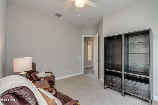 sitting room featuring light carpet and ceiling fan