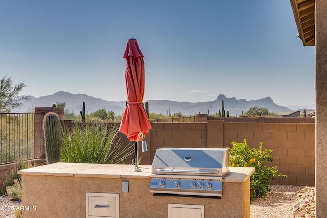 view of patio with area for grilling, grilling area, and a mountain view