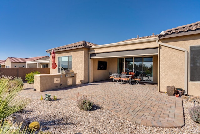 back of property featuring exterior kitchen and a patio area