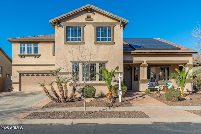 view of front of house featuring a garage, covered porch, and solar panels