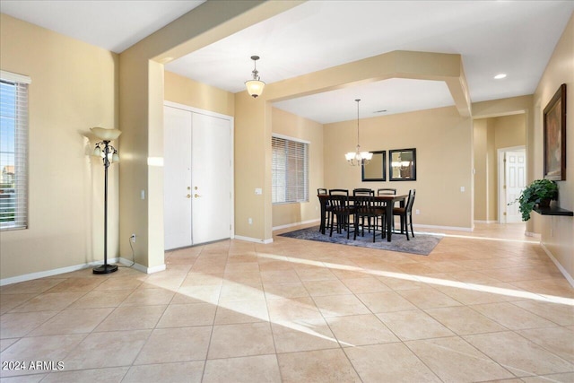 dining room featuring light tile patterned flooring and an inviting chandelier