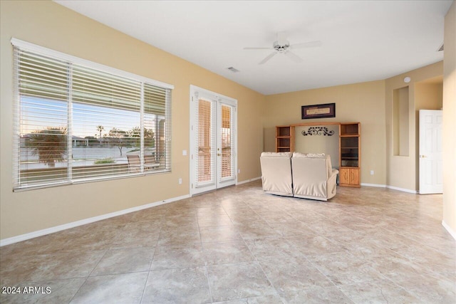 unfurnished living room featuring ceiling fan and french doors