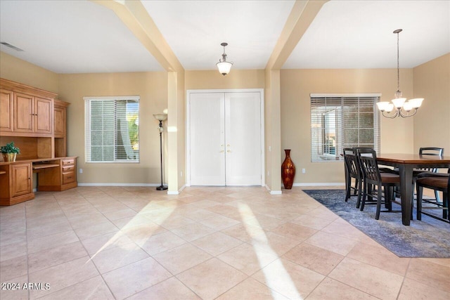 entrance foyer featuring built in desk, a healthy amount of sunlight, and light tile patterned floors